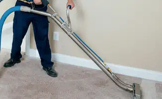 Professional operating a liquid removal machine on a carpeted floor in Rockford, IL